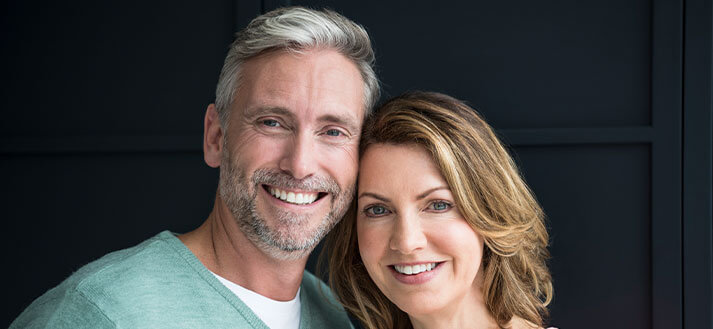 Couple smiling with dark background